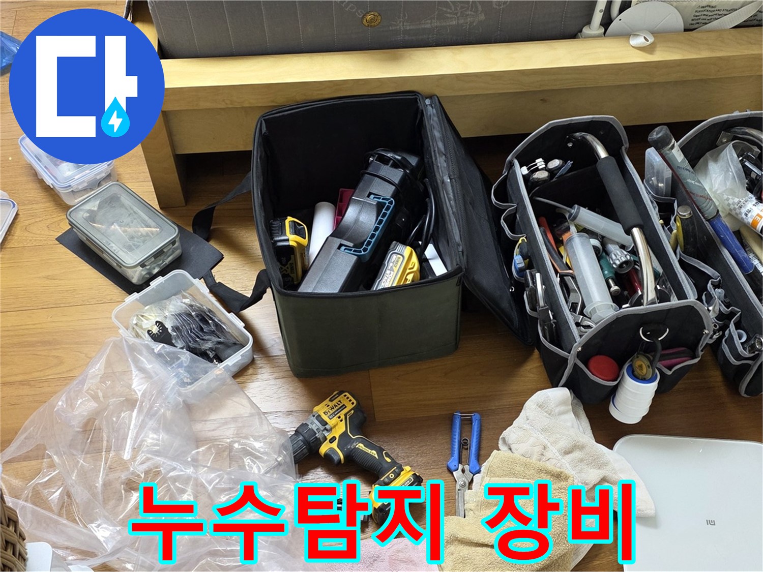 누수 탐지를 위한 다양한 장비들이 바닥에 놓여 있습니다 - 전문적인 누수 해결을 위해 준비된 모습입니다.