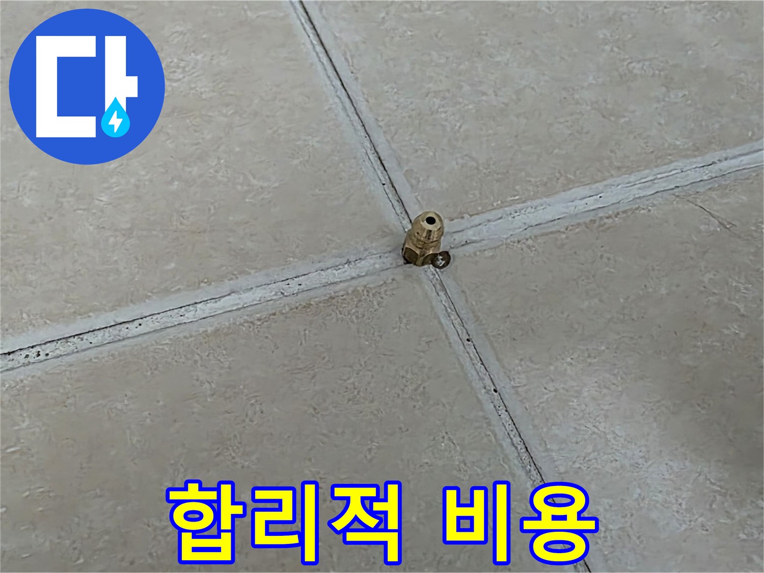 베이지색 타일 줄눈과 금속 배수구 부속의 접합부 모습