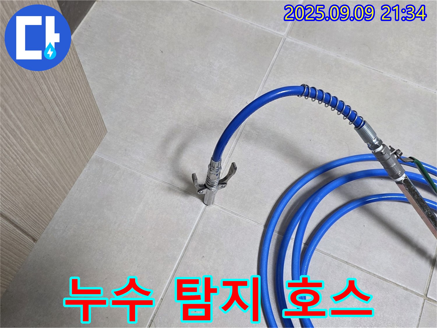 파란색 누수 탐지 호스가 타일 바닥에 놓여진 모습 - 누수 위치를 찾아 완벽하게 차단합니다.