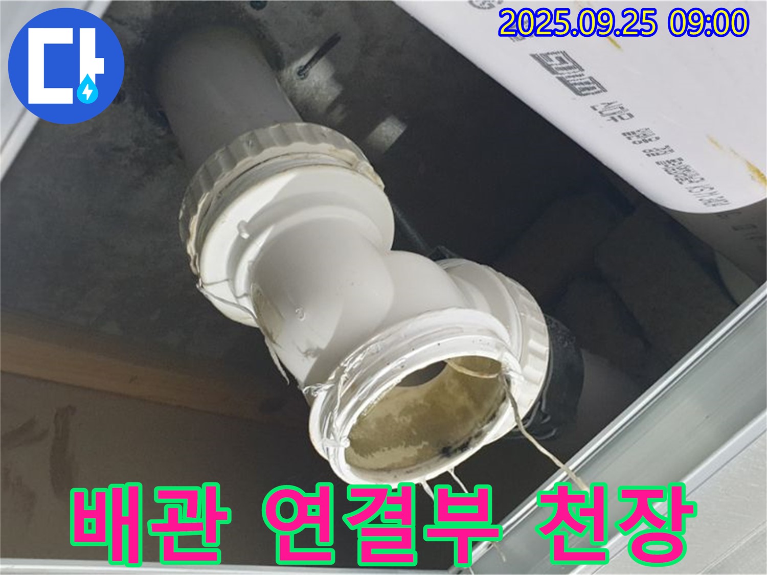 천장 하수 배관 연결 부위에서 누수가 발생하여 물이 떨어지고 있는 모습입니다.