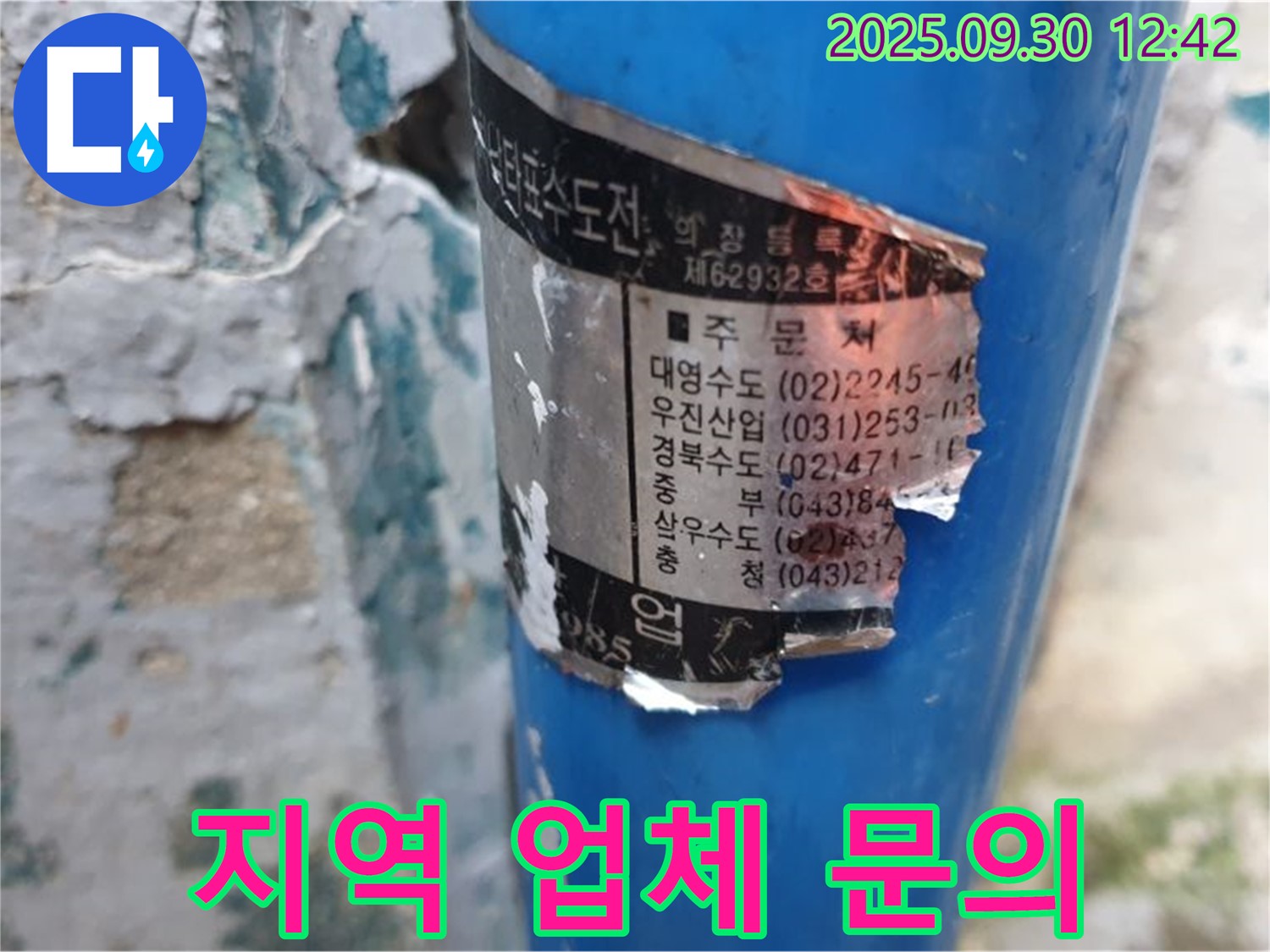 오래된 수도관에 붙은 스티커 - 훼손되었지만, 지역별 시공 업체 정보를 일부 확인할 수 있습니다.
