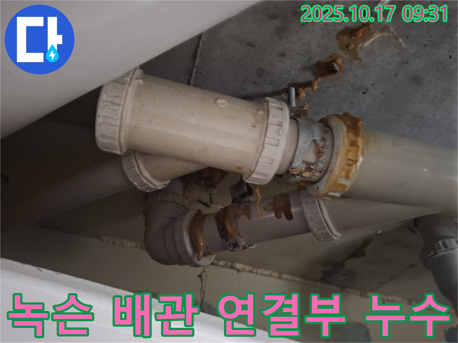 녹슨 배관 연결부 누수 - 배관 연결 부위가 심하게 녹슬어 누수가 발생하고 있습니다 - 즉시 보수가 필요합니다.