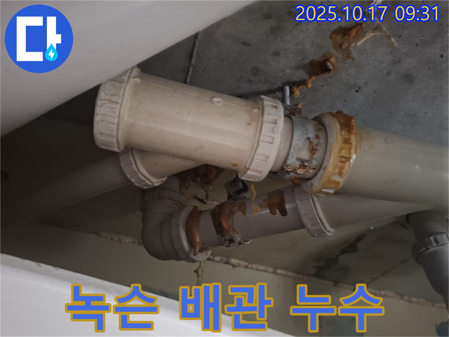 녹슨 배관 연결부 누수 - 배관 연결 부위가 심하게 녹슬어 누수가 발생하고 있습니다 - 즉시 보수가 필요합니다.