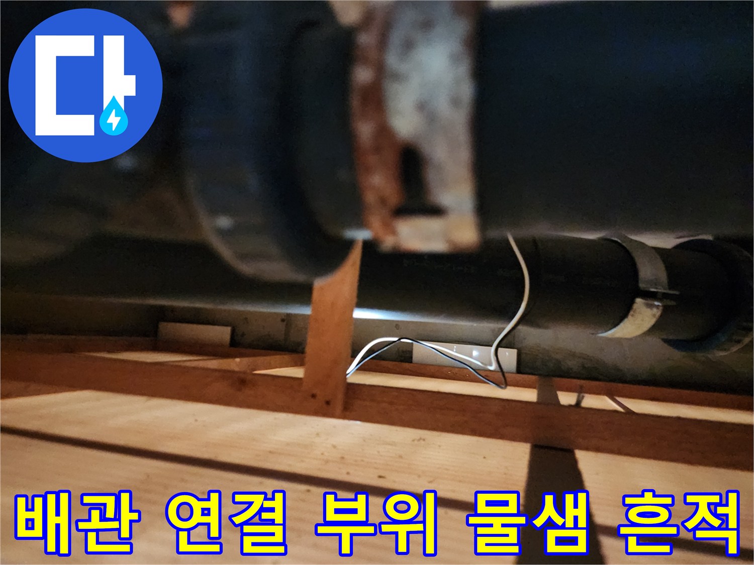 검은색 배관과 녹슨 금속 소켓의 접합 구간 사진