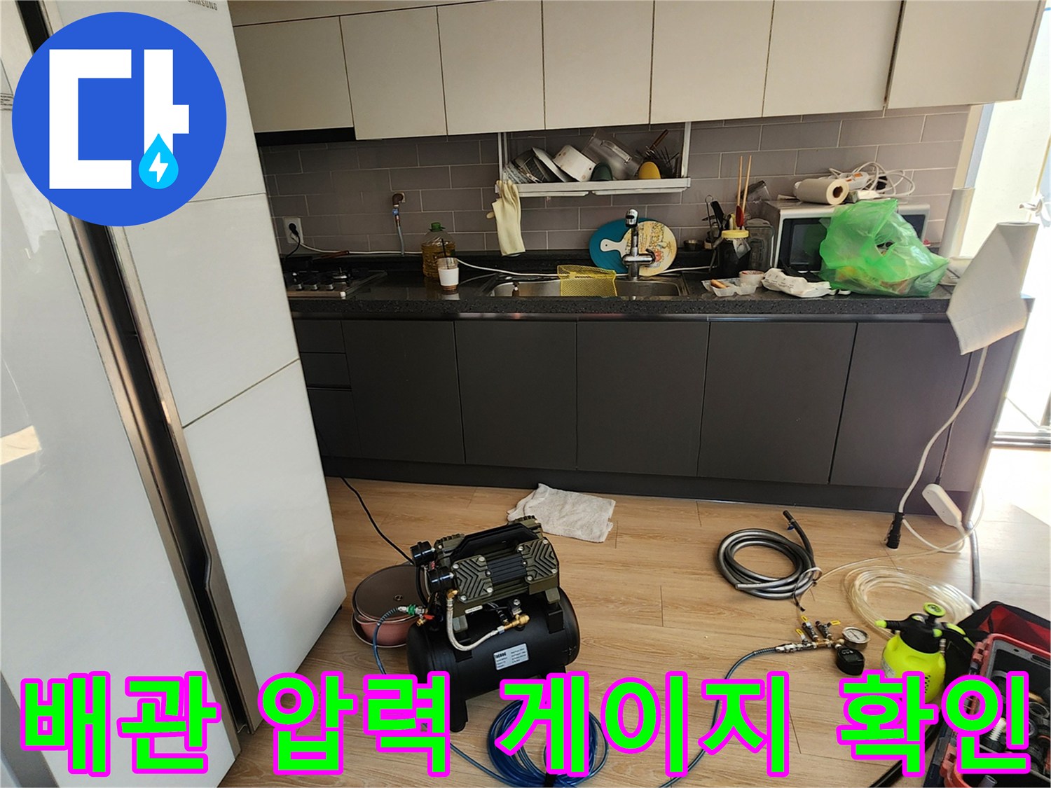 바닥에 놓인 압력계와 파란색 에어 호스가 연결된 상태입니다.
