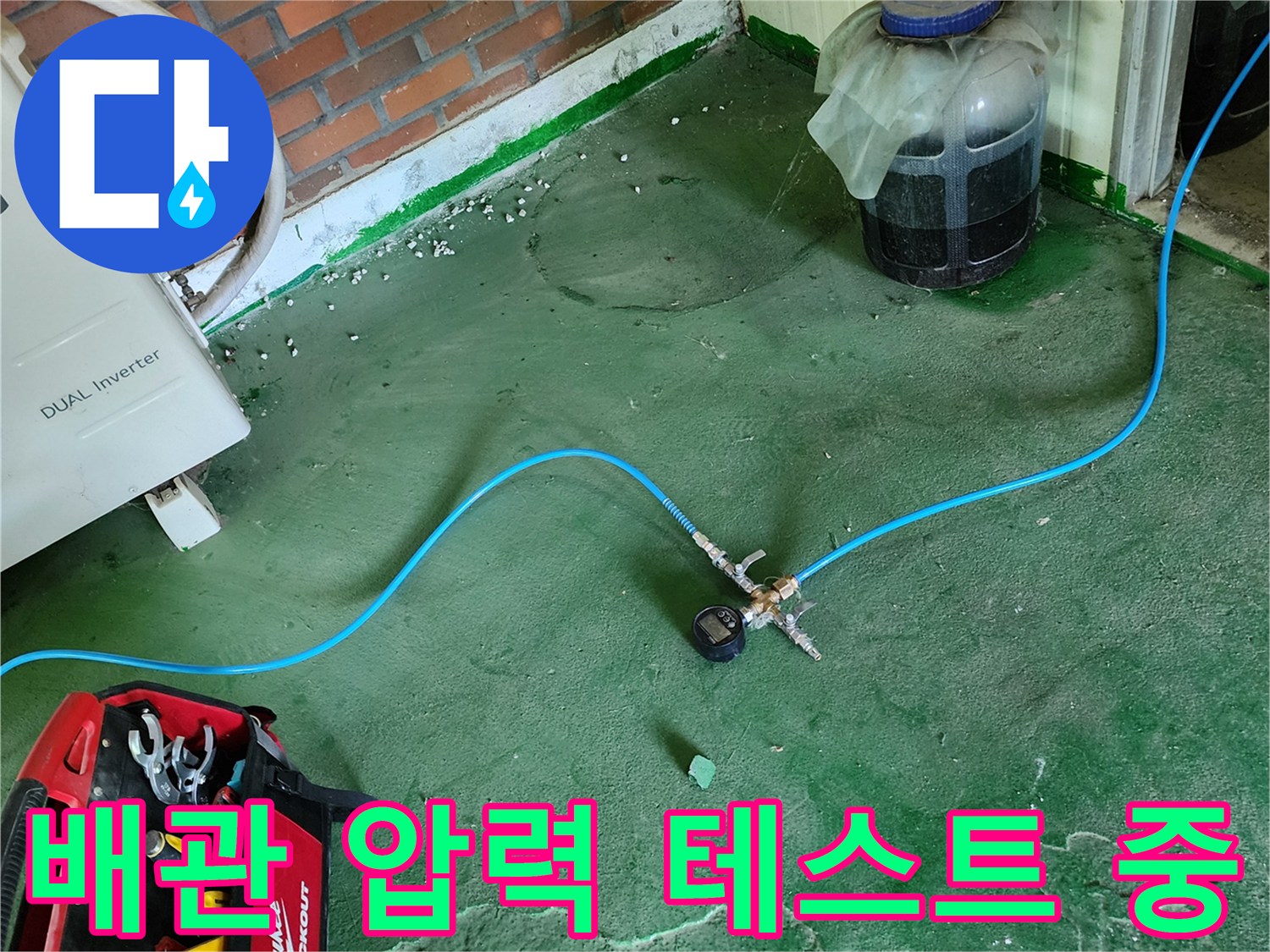 파란색 테스트 호스와 게이지가 연결된 배관 점검 장면