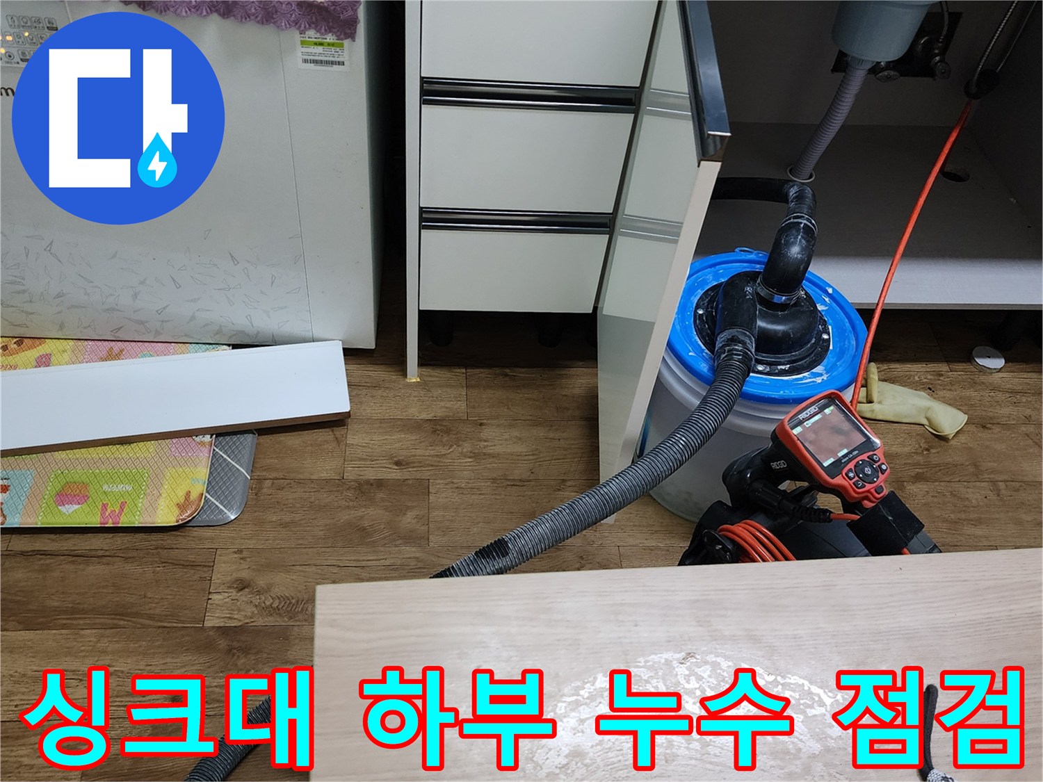 싱크대 아래쪽 수전 연결 부위의 물샘 현상을 진단하는 모습