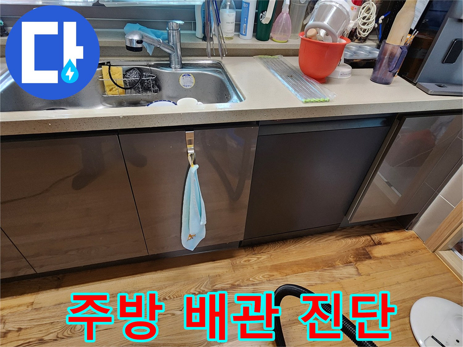 싱크대 주변의 물품들과 함께 하부장 내부를 살펴보는 현장 사진