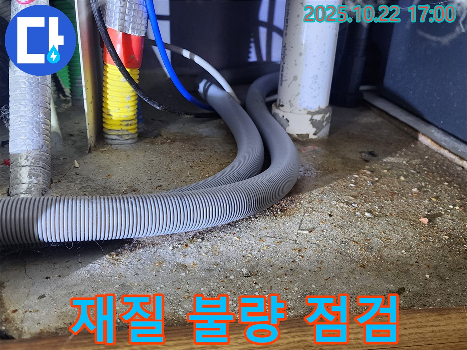 싱크대 하부장 배수 호스를 자세히 살펴보는 모습 - 재질 불량으로 인한 균열 발생 가능성을 점검합니다.