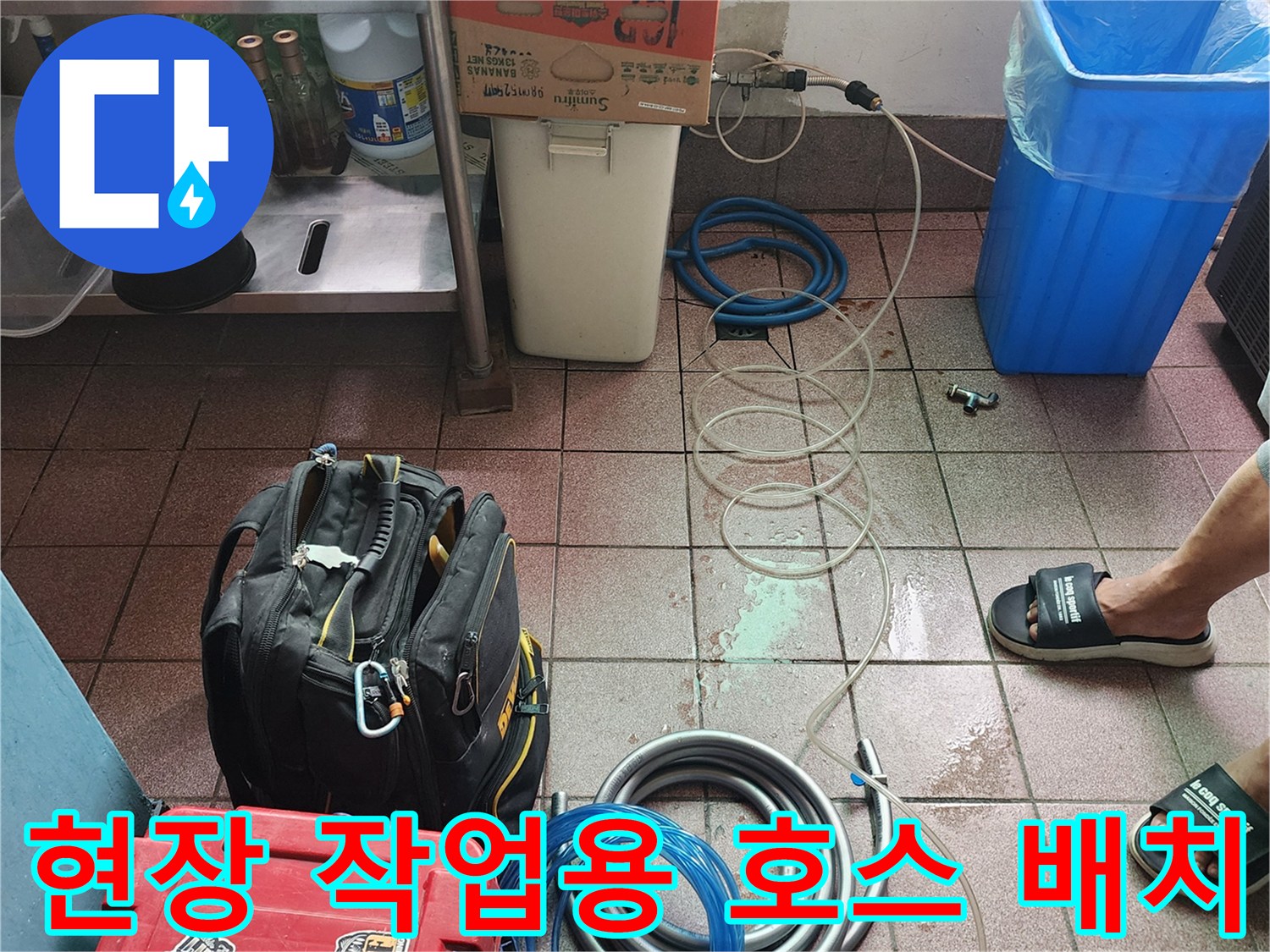 작업 구역 바닥에 정리된 파란색 및 회색 배관 호스들
