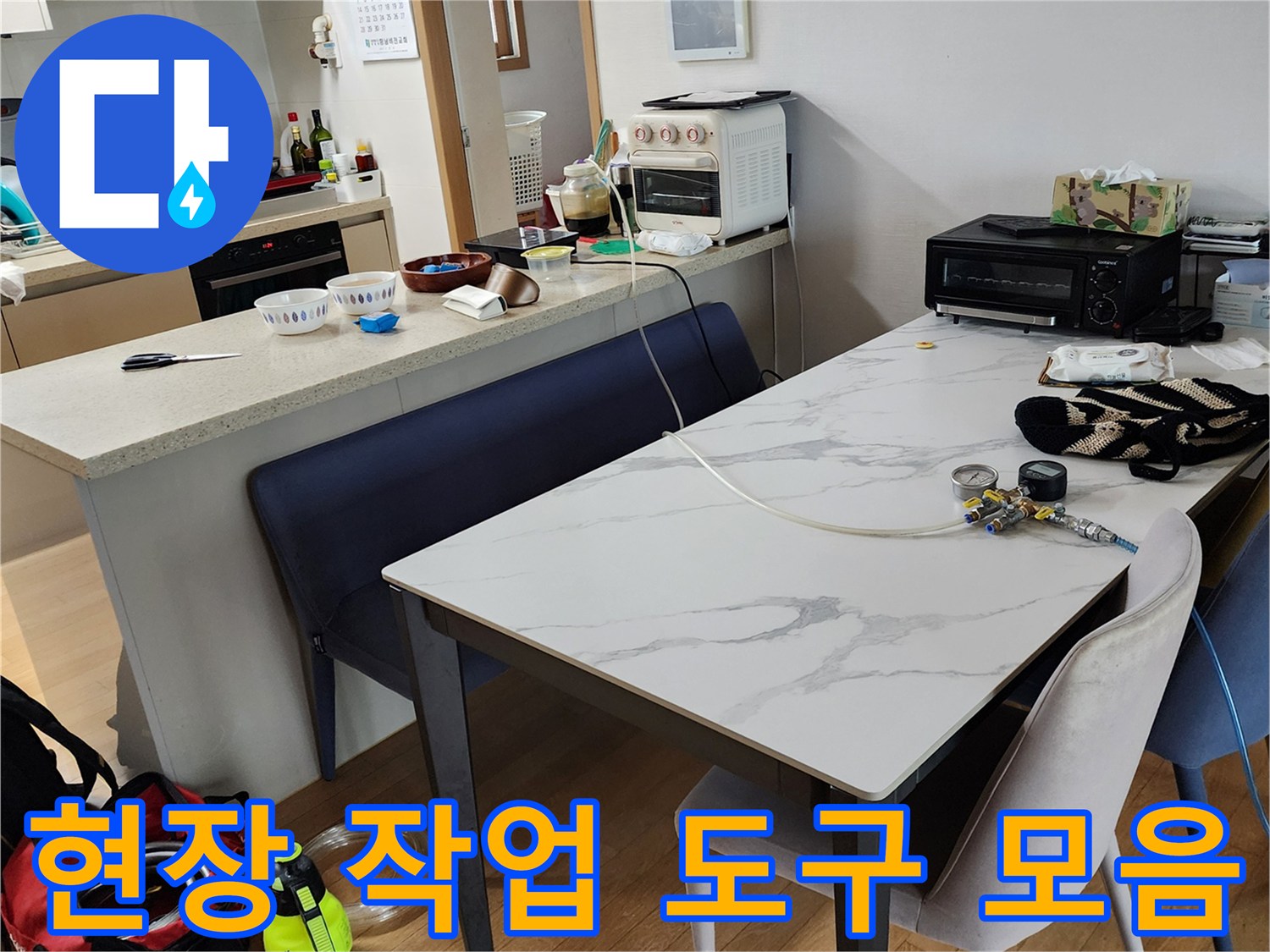 식탁 위에 정렬된 누수 진단용 계측기 및 공구들