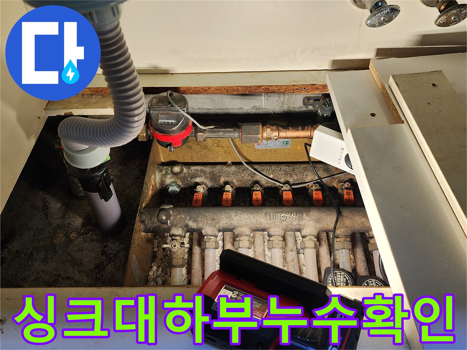 주방 싱크대 아래쪽 배관과 밸브들이 노출된 현장 사진