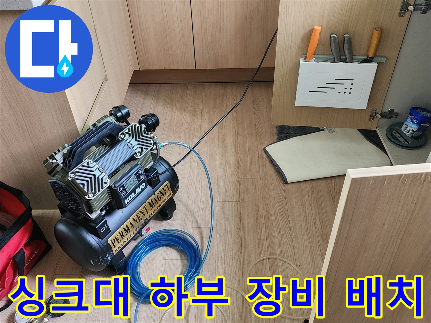 싱크대 아래 공간에 설치된 압력 테스트용 컴프레서