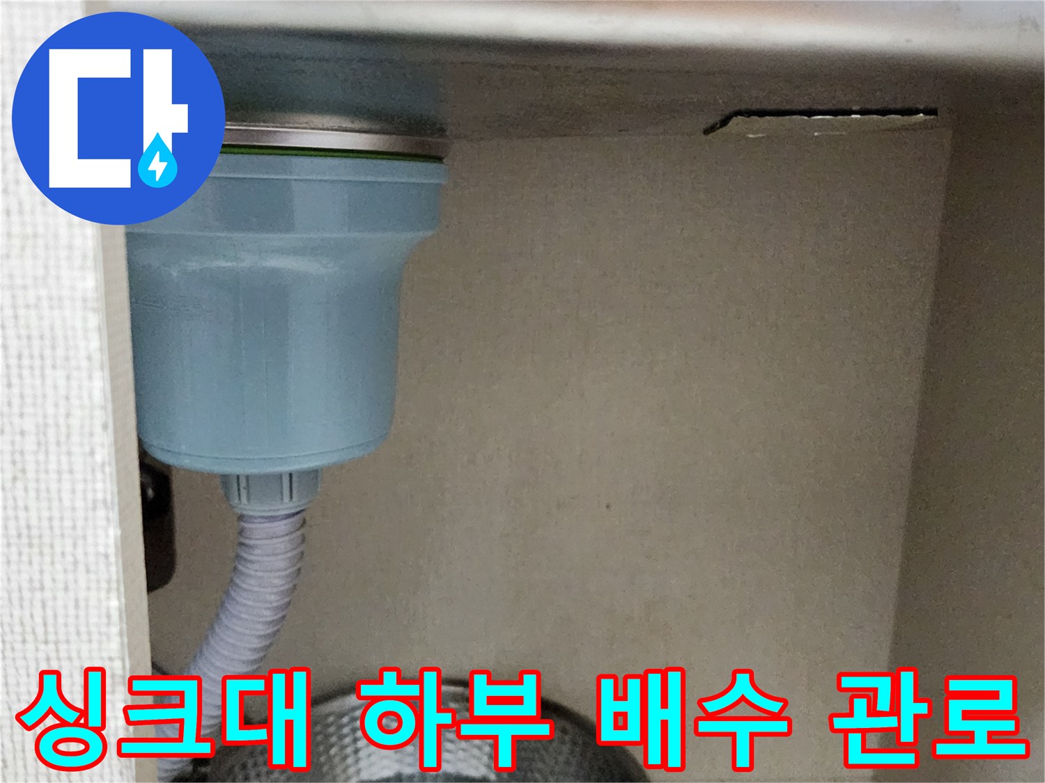 싱크대 아래쪽의 회색 주름관과 스테인리스 볼 모습입니다.
