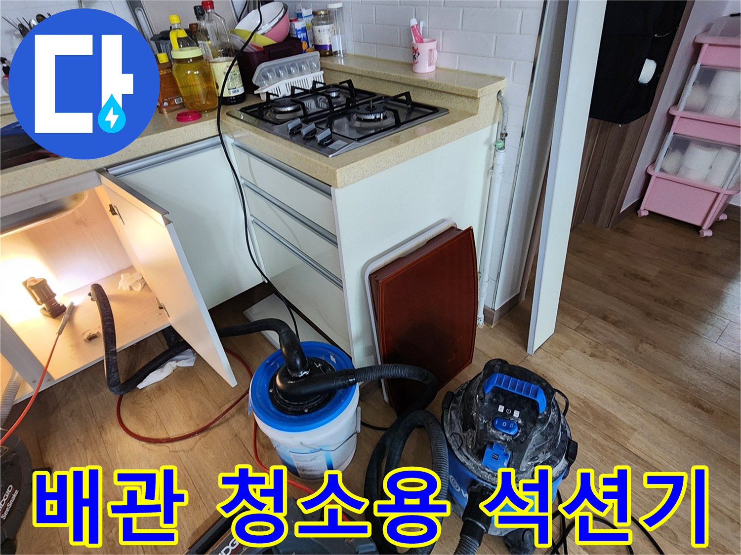 싱크대 하부 배관의 막힘을 해결하기 위해 연결된 전문 석션 호스 및 장비