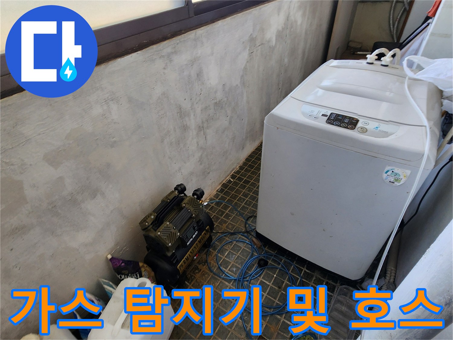 세탁기 옆 바닥에 놓인 가스식 누수 탐지 장비와 파란색 라인