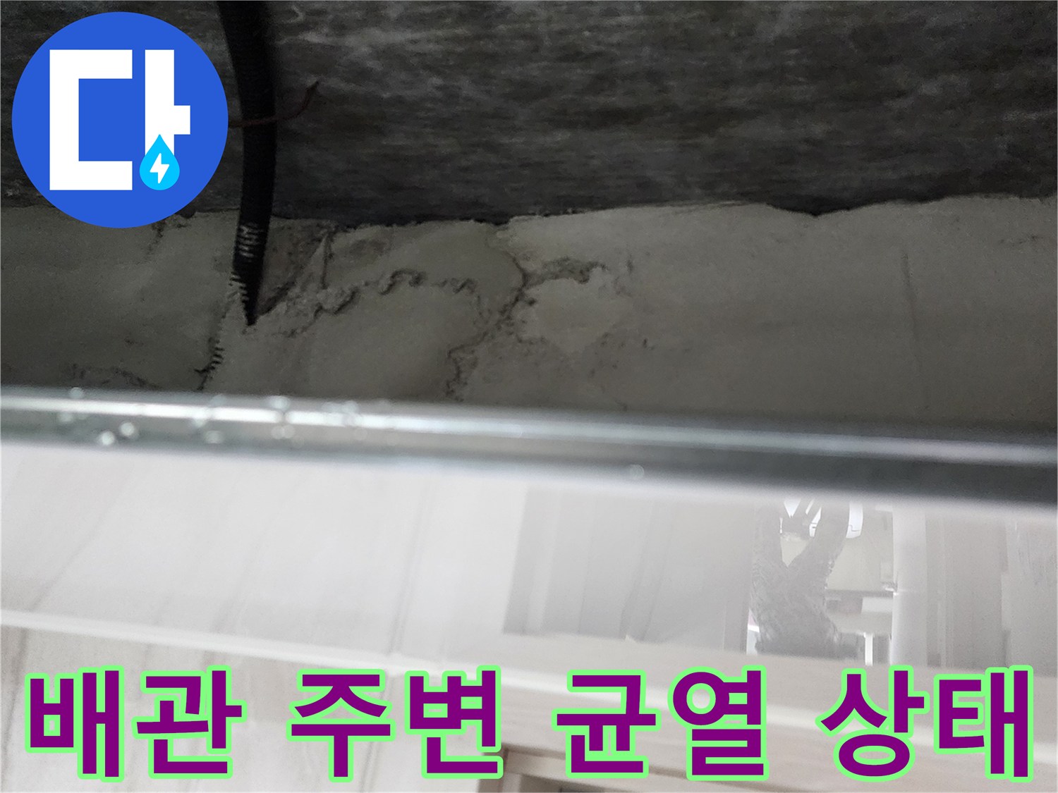 검은색 배관과 콘크리트 벽면 사이의 갈라진 틈새
