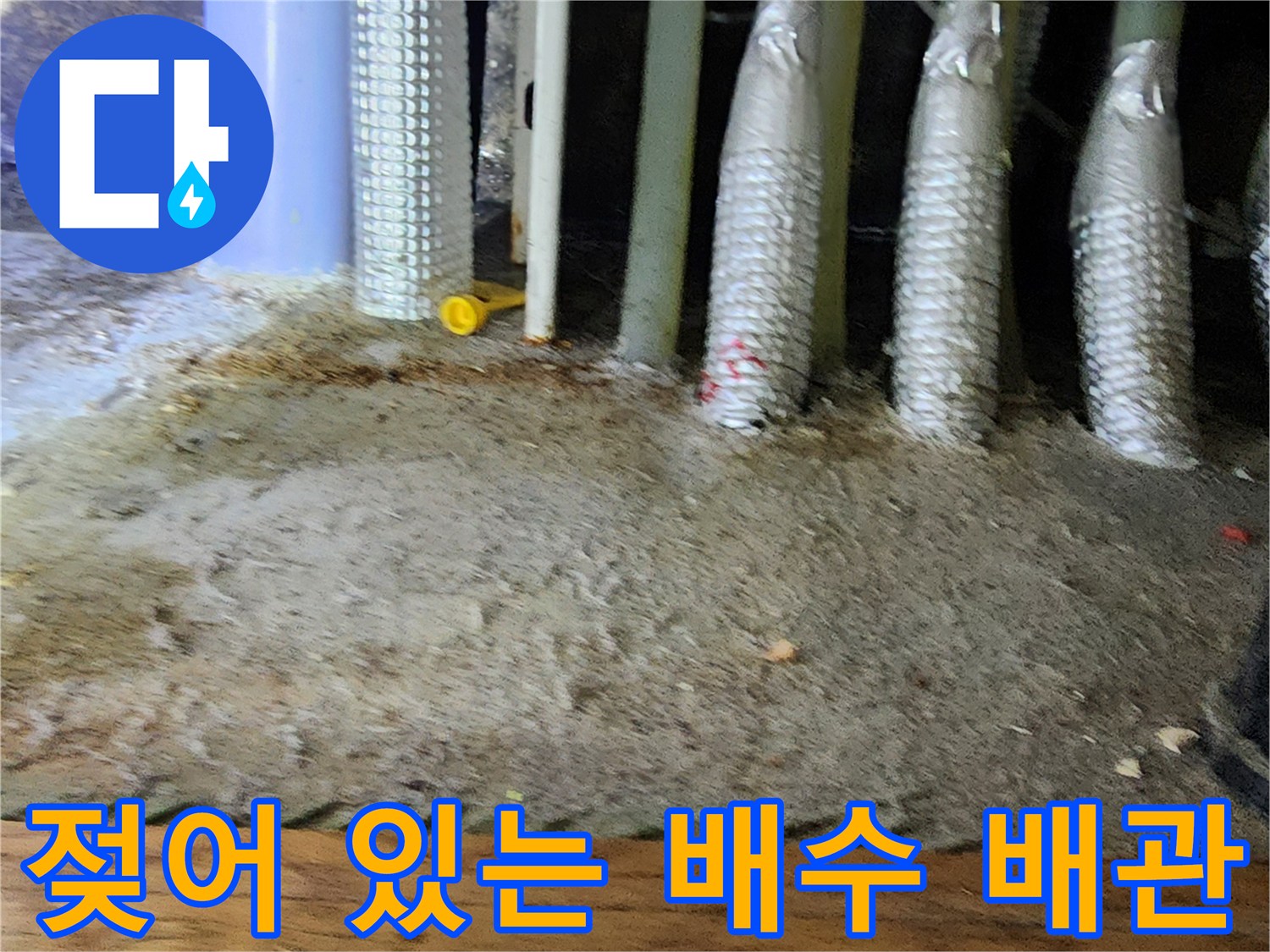 보온재로 감싸진 배수 배관 주변의 습한 바닥 현장