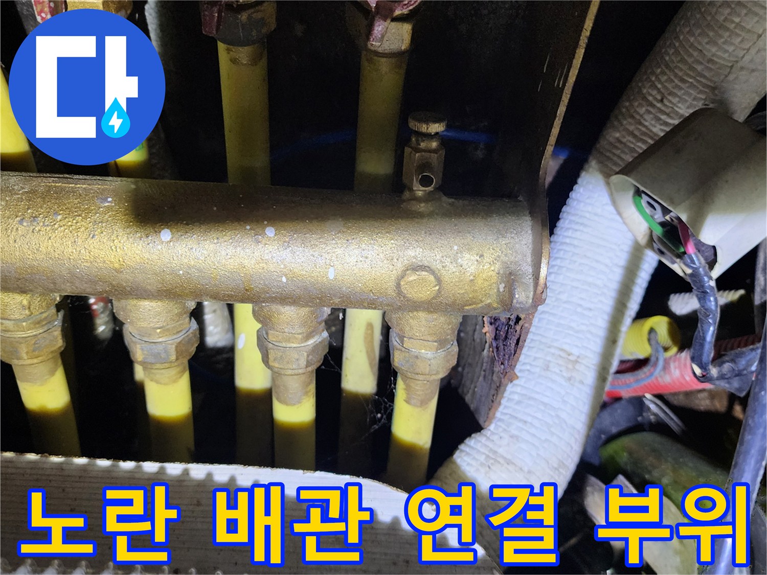 금속 밸브와 노란색 배관이 복잡하게 얽혀 있는 배관 내부 모습입니다.