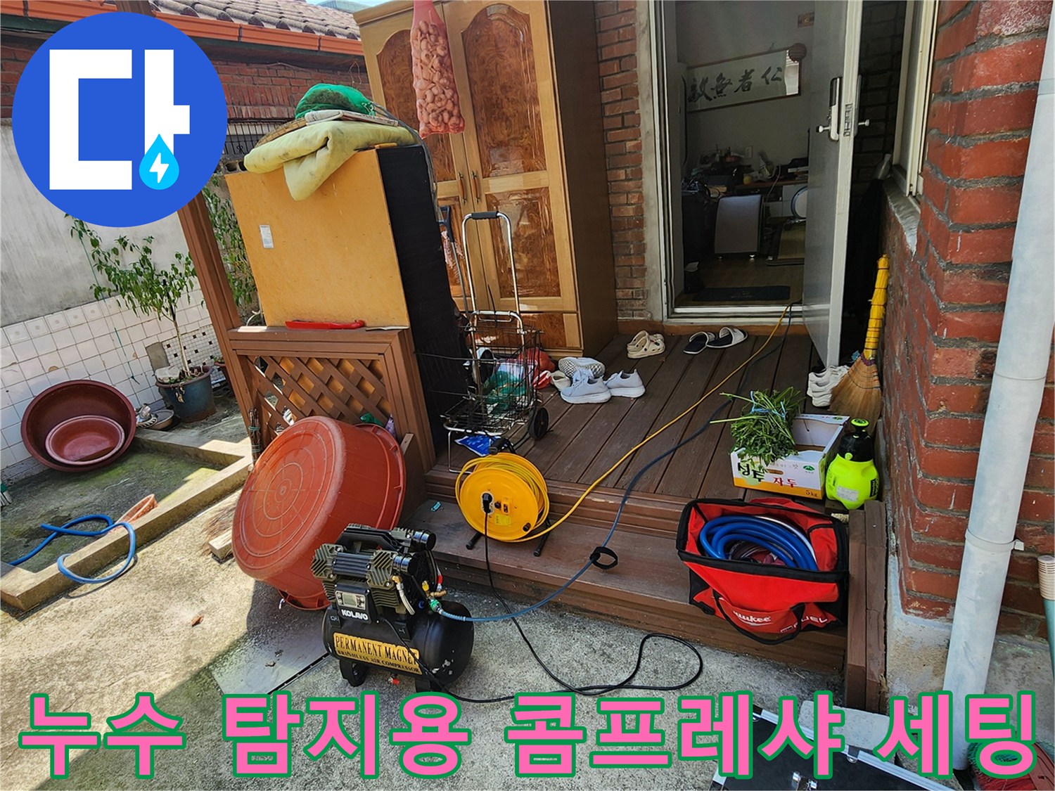 작업 현장 바닥에 놓인 콤프레샤와 노란색 호스 및 작업 도구들
