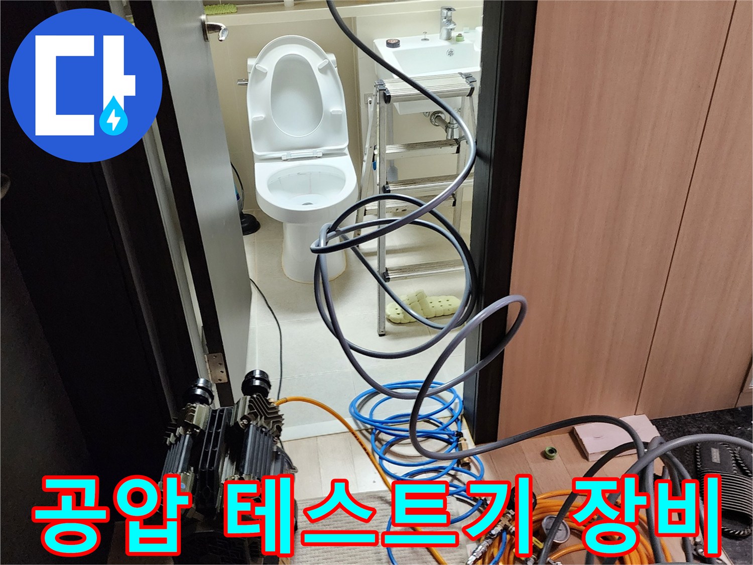 화장실 작업 현장에 설치된 공압 테스트기와 연결 호스