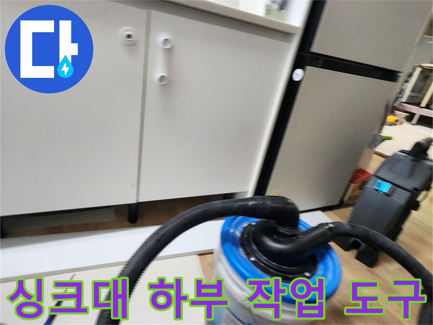 싱크대 밑 바닥에서-작업 중인 배관 흡입 호스와 수거용 용기