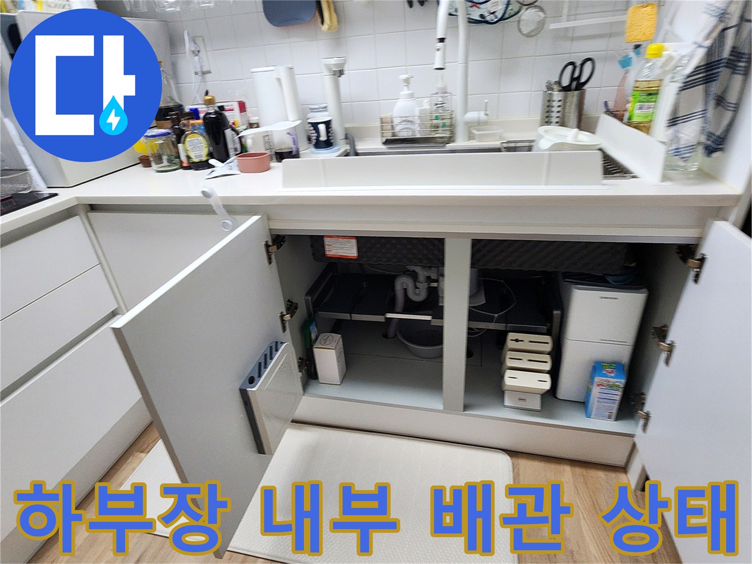 열려있는-싱크대-하부장-안쪽의-배관-및-분배기-주변-모습