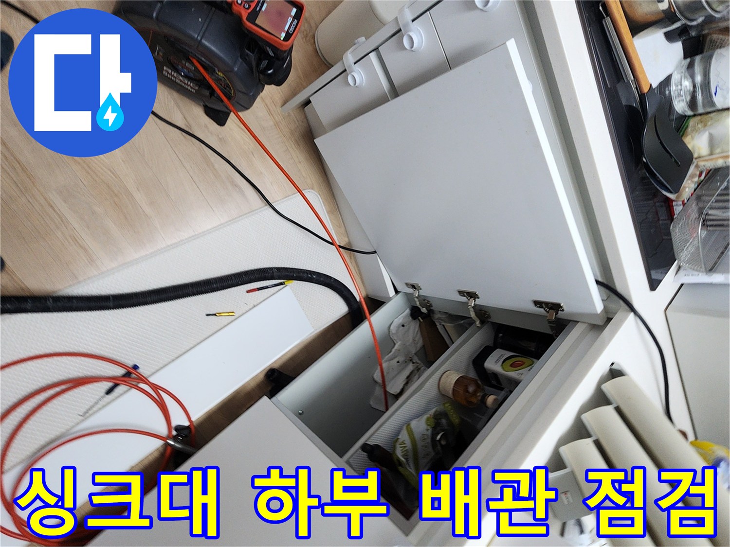 주방 싱크대 아래 배관 상태를 확인하기 위해 내시경 장비를 배치한 모습