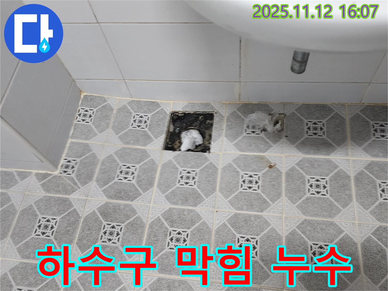 하수구 주변에 물이 고여있고, 하수구 안이 막혀있는 모습 - 복합적인 문제임을 나타냅니다.