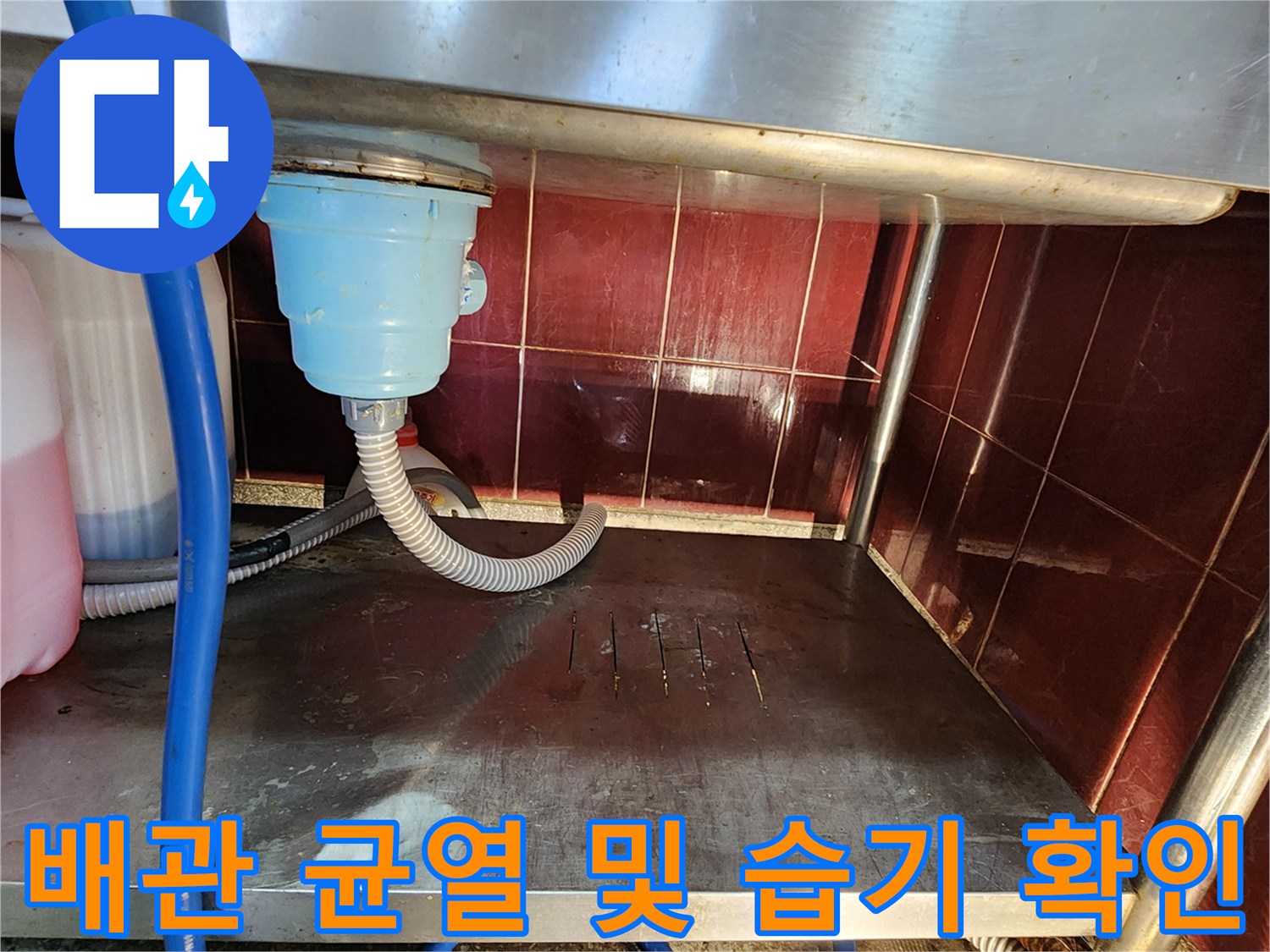스테인리스 선반 아래 배관 주변의 물기 어린 상태를 촬영한 사진입니다.