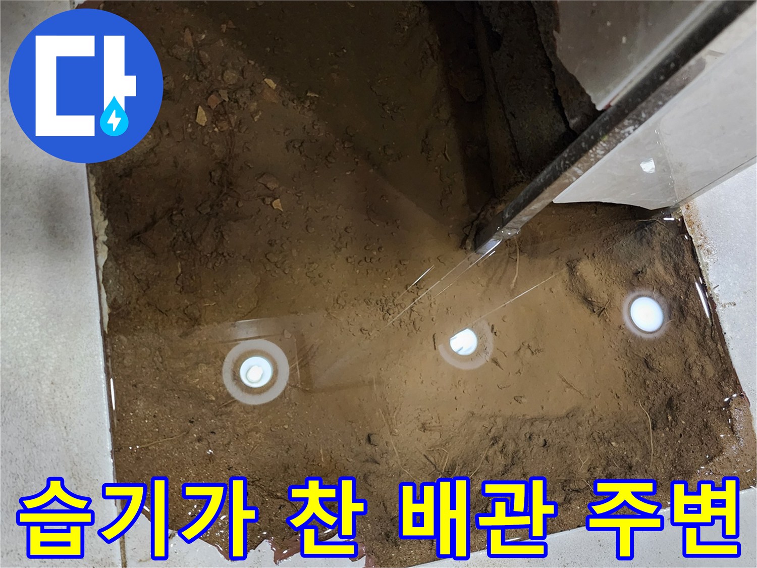 배관 주위의 젖은 모래와 습기가 가득한 굴착 현장 사진
