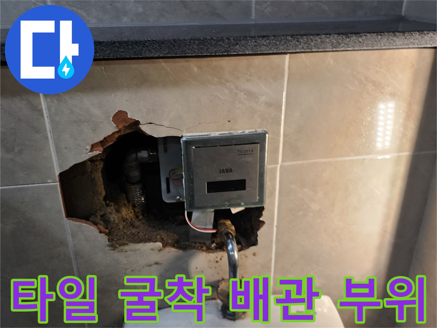 벽면 타일을 제거하여 드러난 소변기 자동 밸브와 연결된 금속 배관입니다.