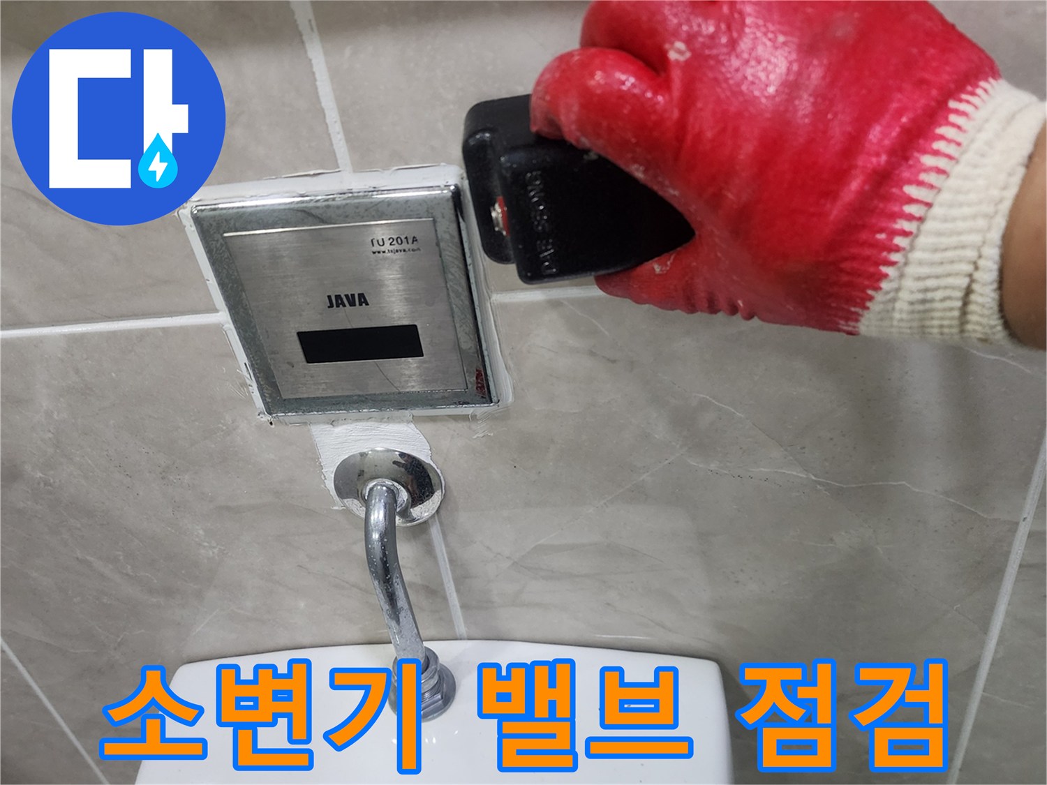 작업자가 소변기 자동 밸브 주변의 배관 연결 상태를 살피는 모습