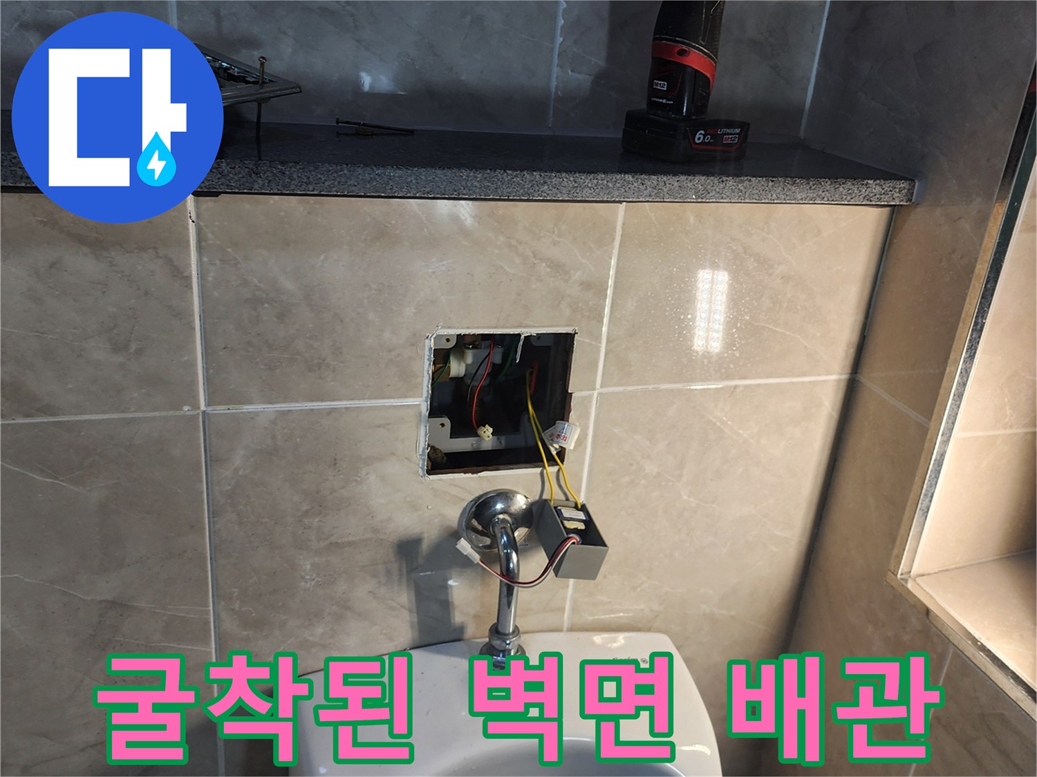 타일을 제거하여 드러난 소변기 급수 배관과 전기 배선