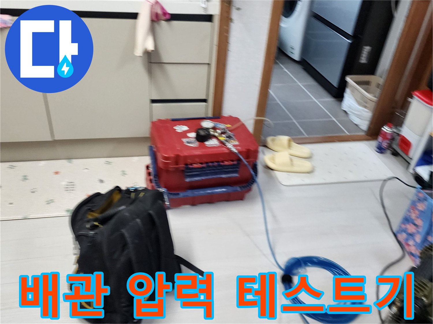 누수 진단을 위해 주방 바닥에 설치된 공압 측정 장비와 호스 연결 상태