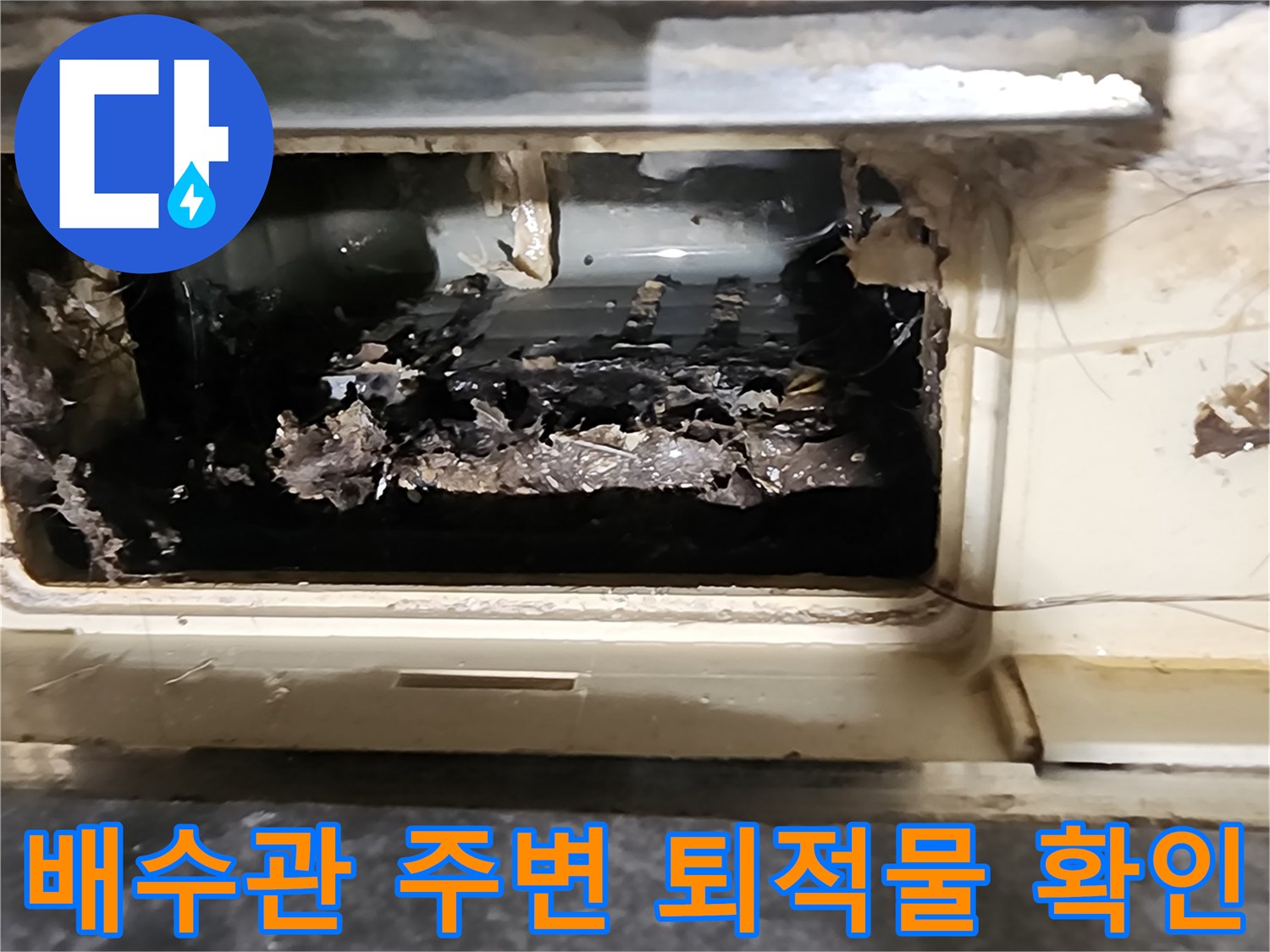 배관 주위에 젖은 슬러지와 오물이 퇴적되어 있는 사진입니다.