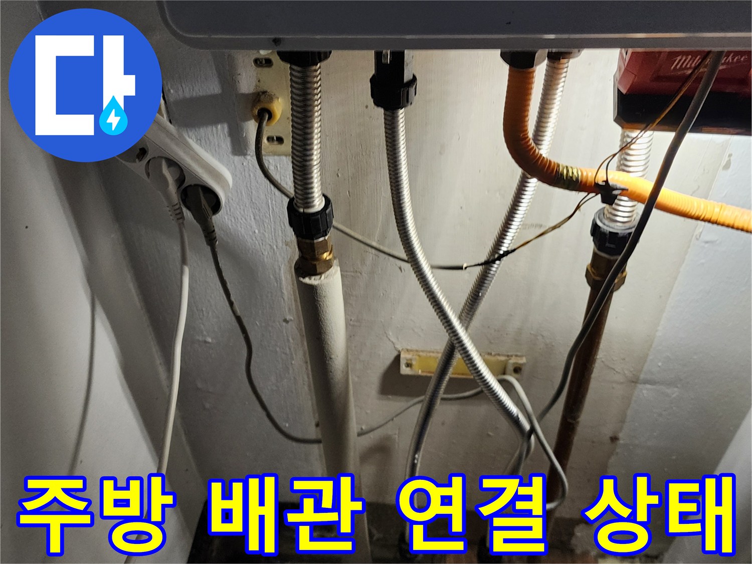 싱크대 하부장 아래의 복잡한 배관과 연결 부위 모습