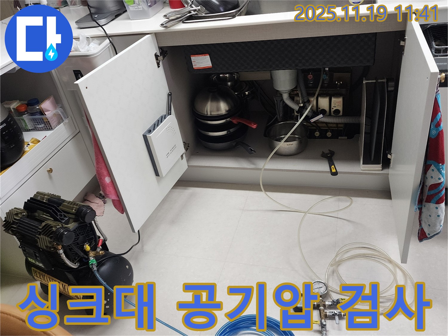 포천시 내촌면 마명리 누수 현장 - 싱크대 하부에서 공기압 검사를 진행하기 위해 장비를 설치하고 꼼꼼하게 준비하는 모습입니다.