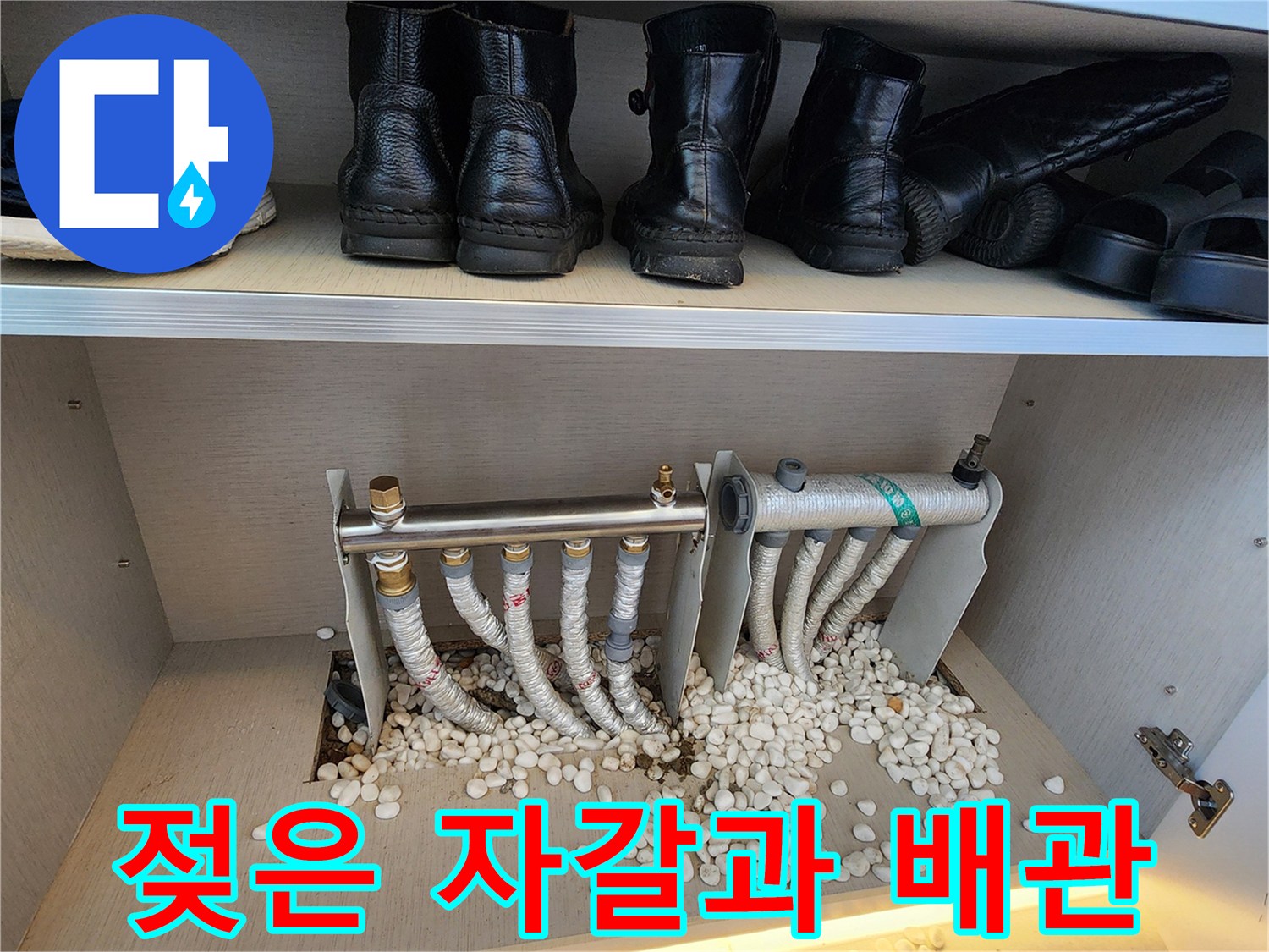 분배기 하부의 젖은 자갈과 보온재 처리된 배관 사진입니다.