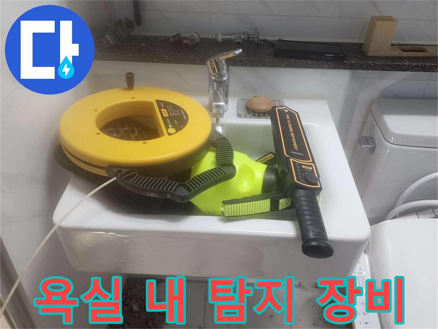 세면대 위에 놓인 노란색과 검은색의 누수 탐지 기구들