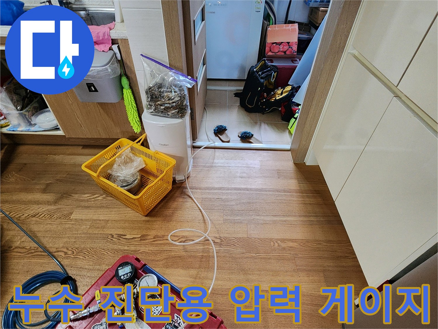 붉은색 공구함 위에 거치된 배관 압력 측정 게이지와 연결 호스