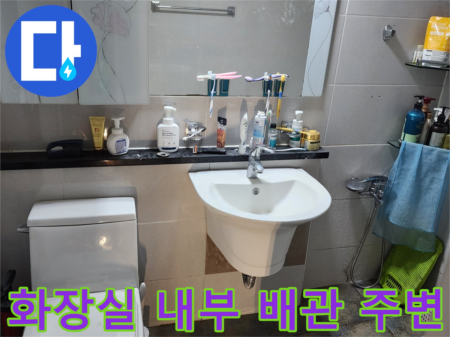 세면대와 변기가 설치된 화장실의 벽면 상태 사진입니다.