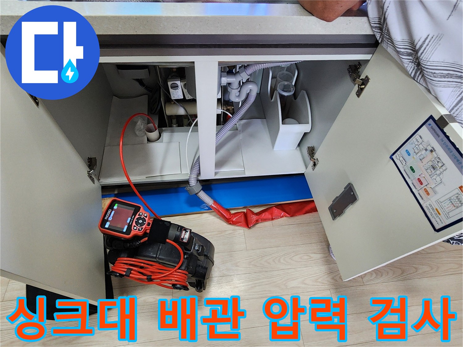 싱크대 하단 배관에 연결된 빨간색 공압 호스와 측정기 화면