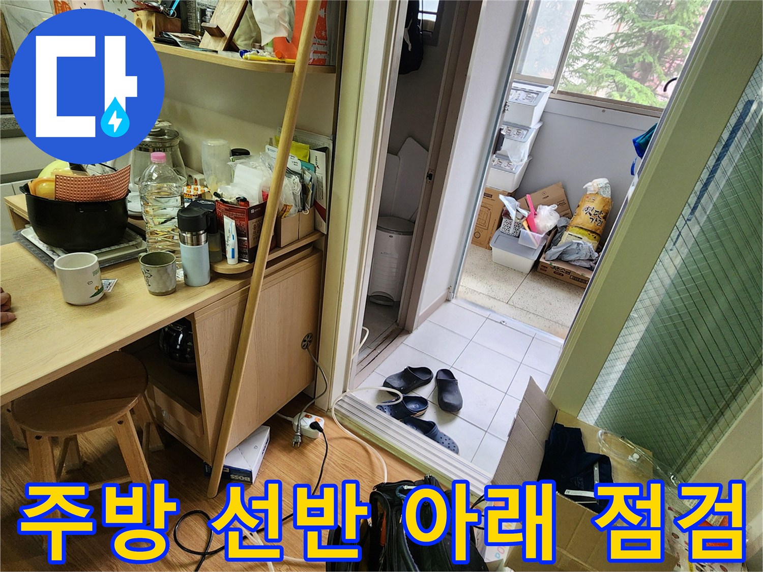 주방 수납장 밑 공간-누수 경로를 추적하기 위한 현장 조사 모습