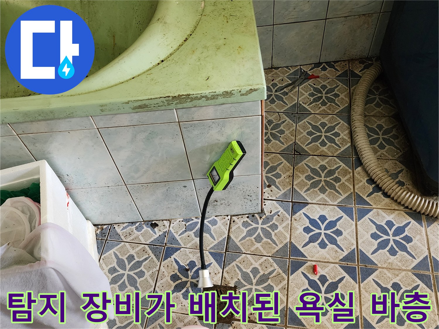 욕실 하수구 근처에 놓인 가스 탐지기와 호스 연결 상태