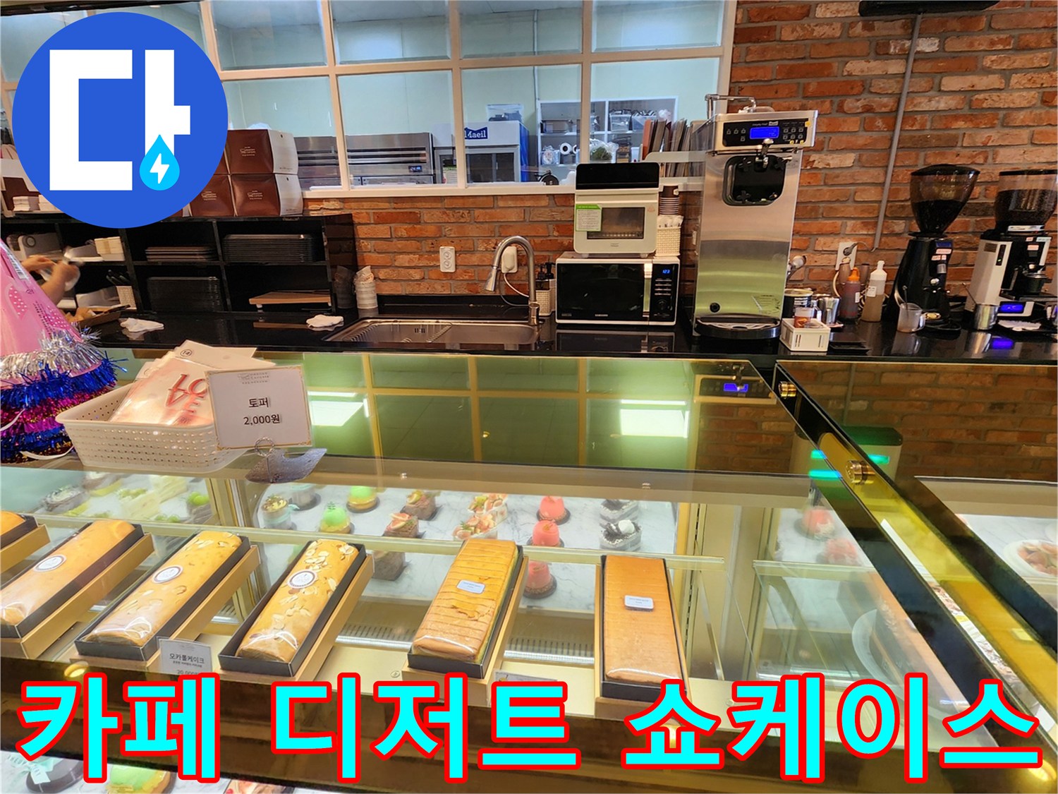 다양한 종류의 케이크와 빵이 진열되어 있는 유리 쇼케이스입니다.