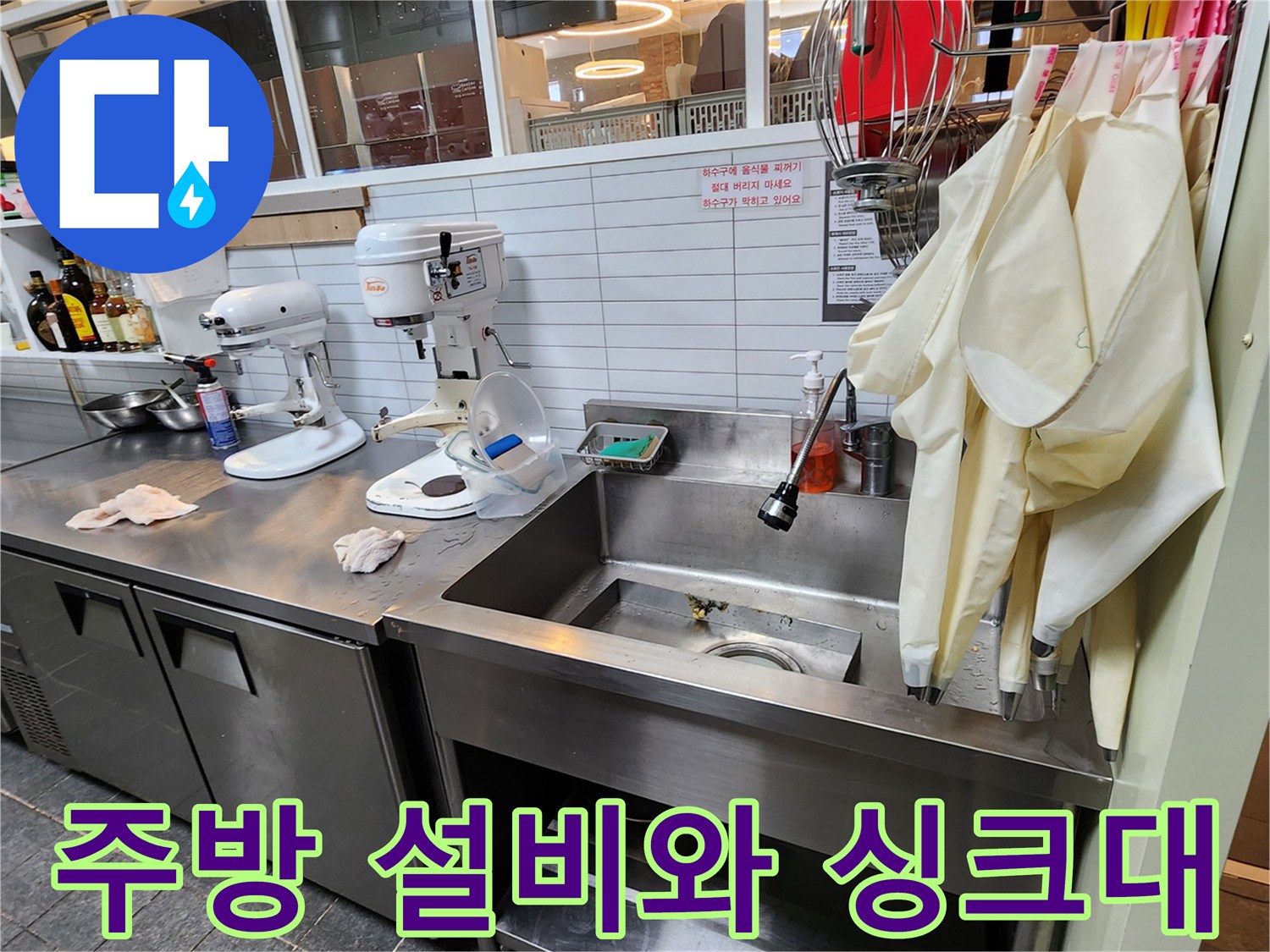 카페 주방 내 커피 머신과 스테인리스 싱크대 배치 상황 - 배관 점검 대상 구역