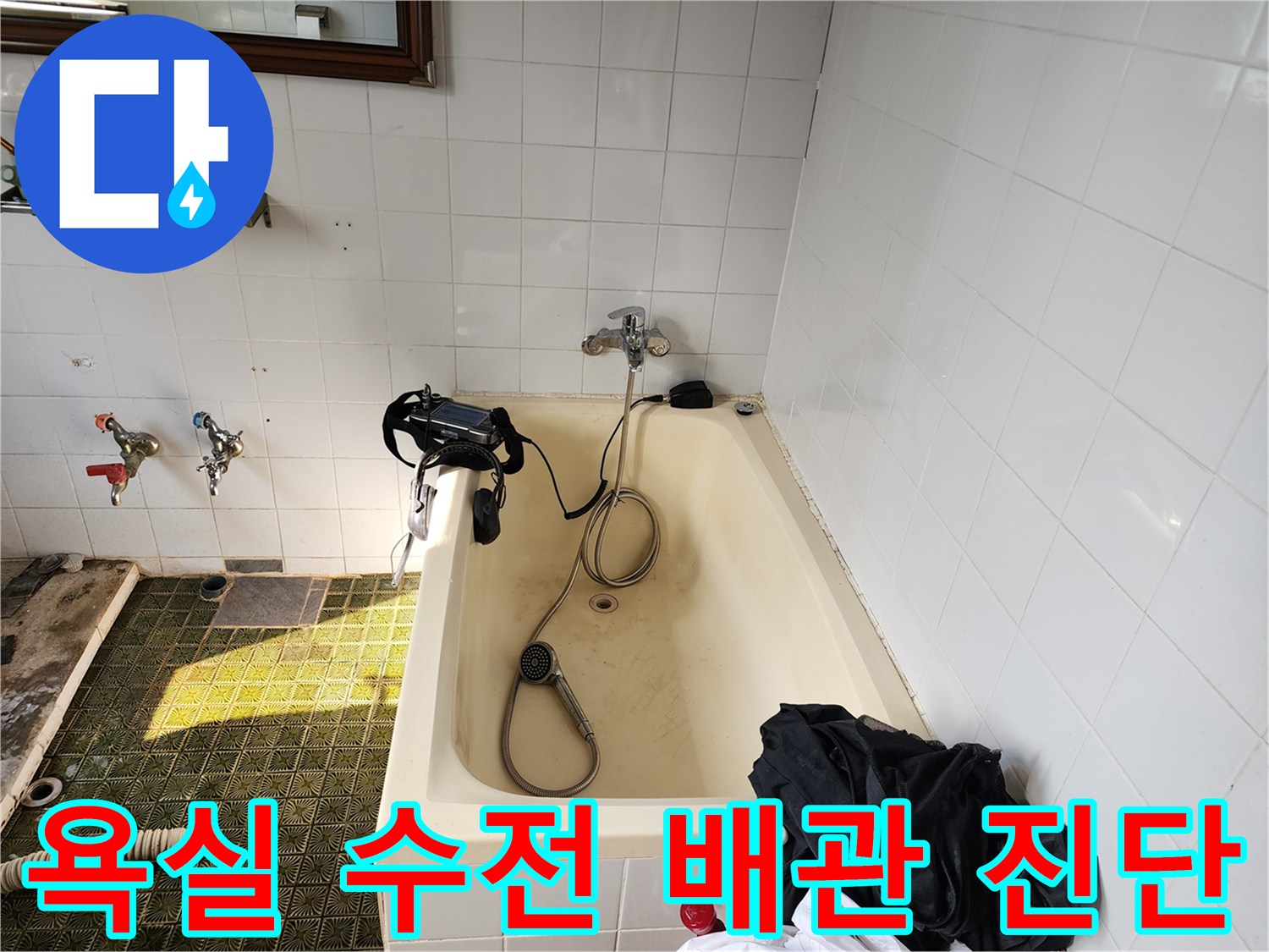 욕조 근처에 설치된 수전과 샤워기 호스 부위의 상태를 확인하는 중입니다.
