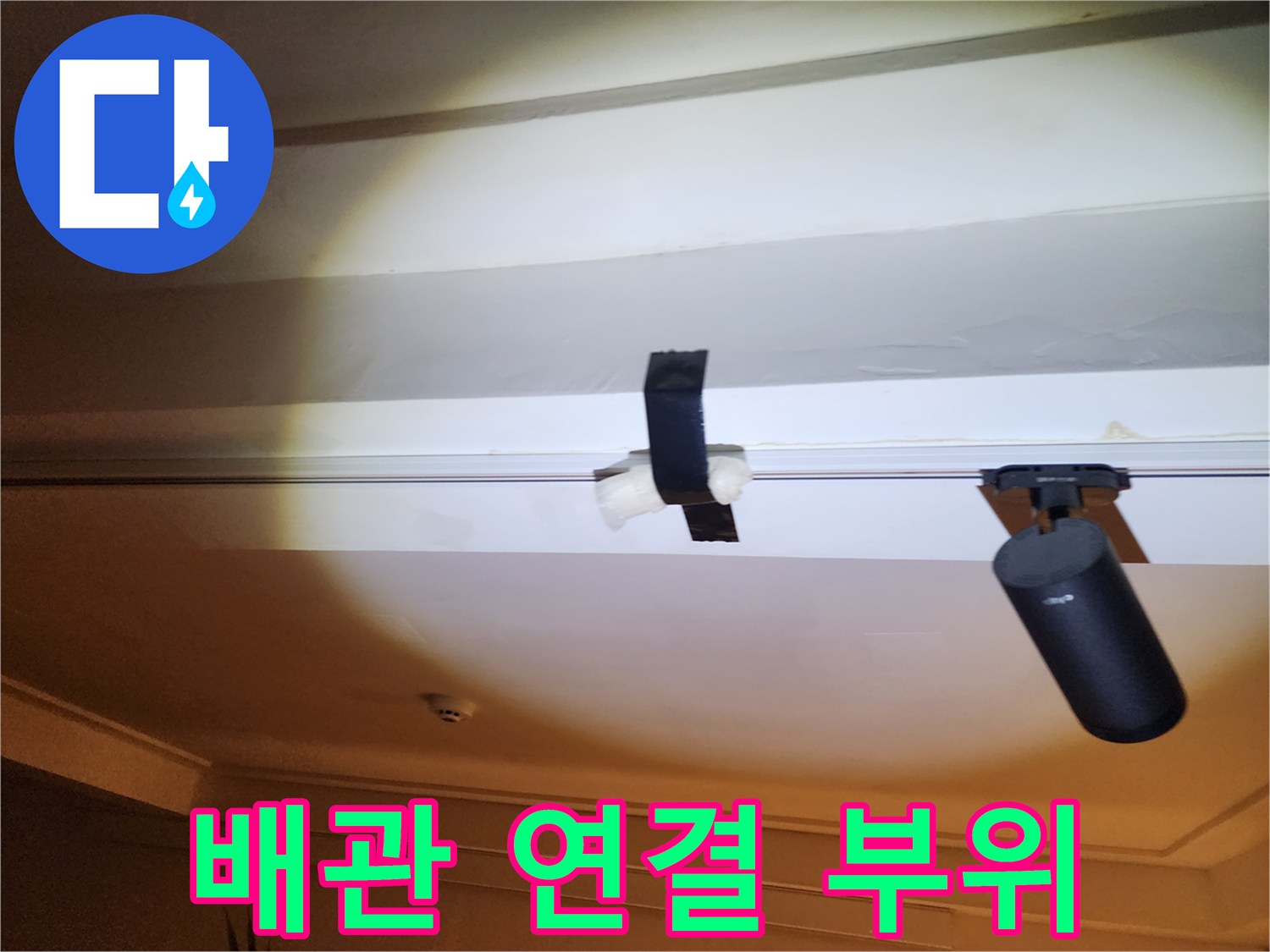 천장 구조물에 고정된 배관의 결합부를 촬영했습니다.