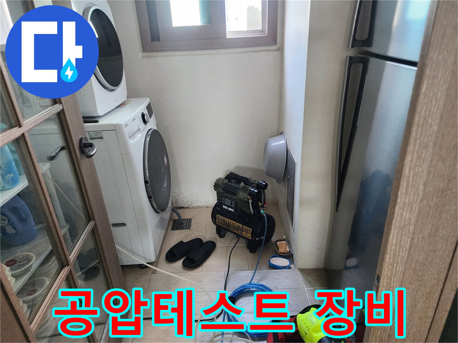세탁기와 냉장고 사이-배관 압력 측정을 위해 준비된 에어 컴프레셔